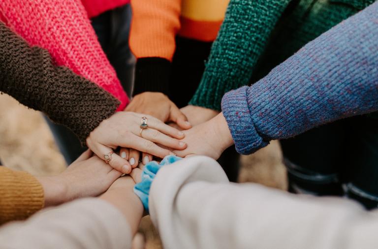 Group of people putting their hands together