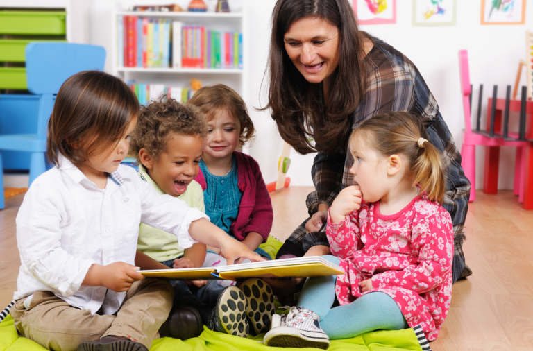 Early years children sat on floor with adult
