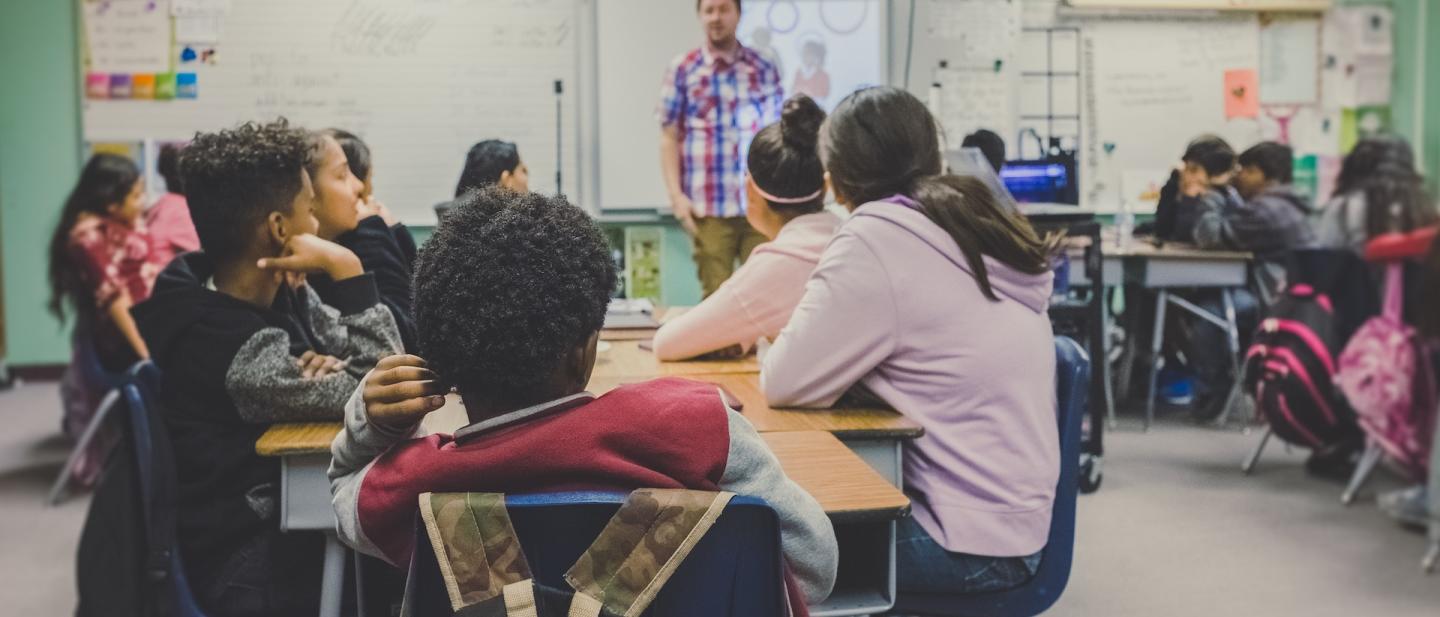 school classroom scene with teacher at the front